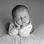 baby, newborn, sleeping, infant, portrait, black_and_white, monochrome, studio, closeup, peaceful, blanket, knitted_sweater, small_hands, hands_under_chin, eyelashes, soft_texture, cozy, delicate, head, face