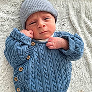 Aidan a rejoint le concours — aidez-le/la à gagner de superbes lots ! baby, beanie, blanket, blue_sweater, close_up, cozy, cute, expressive_face, hat, indoors, infant, knitwear, lying_down, newborn, portrait, sleepwear, small_hands, soft_texture, warm_clothing, wooden_buttons