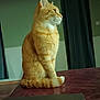 cat, orange_tabby, indoor, sitting, tail, curled_tail, fur, whiskers, side_profile, window_curtains, wall, table_surface, domestic_cat, pet, feline, calm, thoughtful, animal, mammal, household