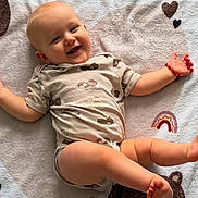 Leandro a rejoint le concours — aidez-le/la à gagner de superbes lots ! baby, smiling, infant, blanket, cute, happy, lying_down, child, soft_texture, patterned_clothing, heart, rainbow, playful, arm_band, skin, foot, head, face, expression, indoors