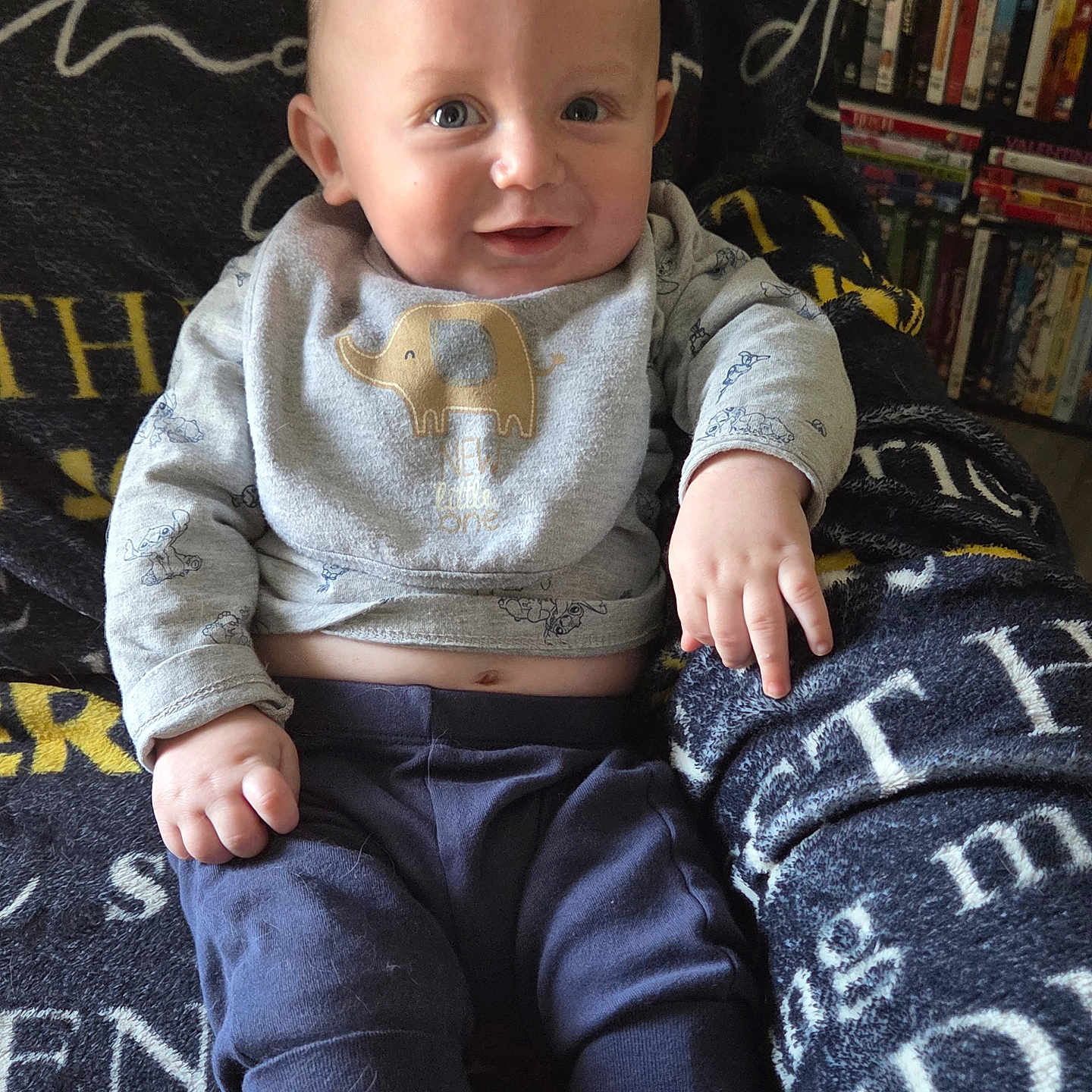 Aulcard joined the competition — help win amazing prizes! baby, child, infant, smiling, portrait, sitting, indoors, blanket, bookshelf, books, clothing, elephant_shirt, long_sleeves, trousers, face, eyes, hands, furniture, home, photography