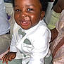 child, toddler, smiling, happy, suit, bow_tie, green_pants, indoor, party, people, seated, face, african_american, hair, clothing, button_up, portrait, celebration, cute, baby