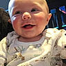 Noah is registered to the contest to win money with this photo: baby, child, close_up, clothing, couch, eyes, face, furniture, happy, head, home, indoor, infant, joy, mouse_pattern, pajamas, portrait, seated, smiling, white_clothing