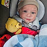 Noah joined the competition — help win amazing prizes! baby, infant, child, car_seat, hat, blanket, stuffed_animal, teddy_bear, winnie_the_pooh, portrait, face, eyes, looking_at_camera, sitting, indoors, vehicle, travel, cozy, red_clothing, blue_blanket