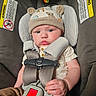 baby, infant, child, car_seat,  안전_harness, hat, bear_hat, toys, portrait, face, eyes, pouting, sitting, indoors, vehicle, safety_belt, buckled, clothing, close_up, photography