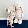 Jaxson is registered to the contest to win money with this photo: toddler, child, plush_toy, stuffed_animal, bunny_costume, onesie, barefoot, carpet, indoor, wall, cute, soft_toy, baby, toy, ribbon, floppy_ears, standing, side_view, pastel_colors, playtime