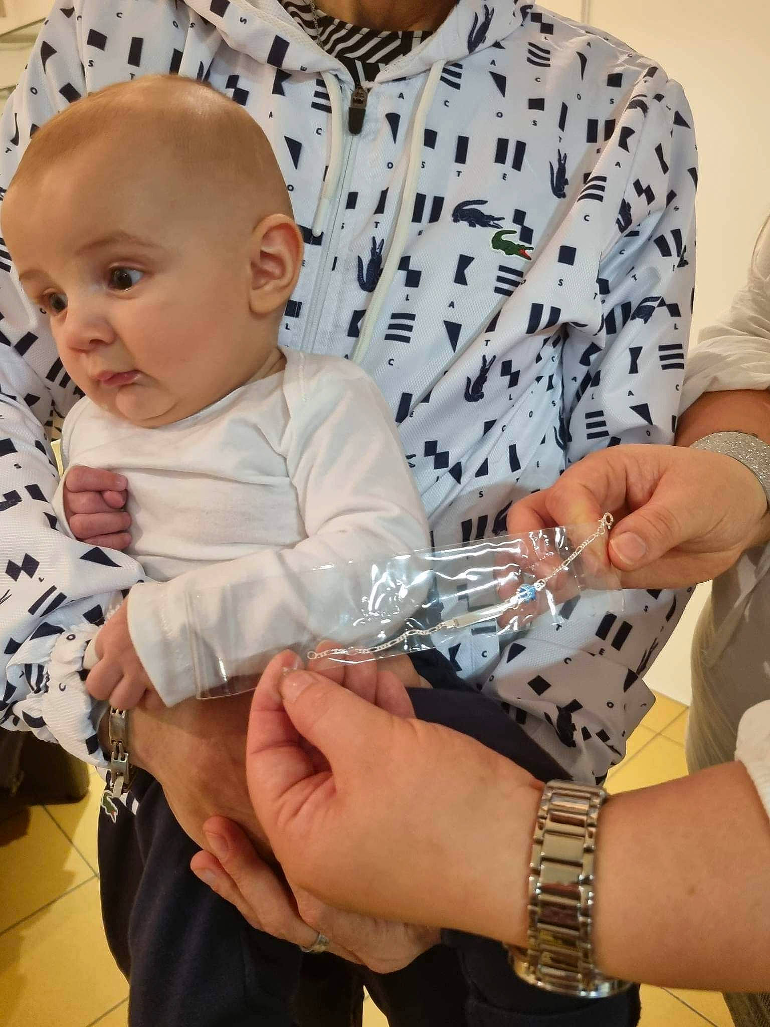 Alban participe au concours pour gagner de l'argent avec cette photo : baby, baby_toddler_clothing, bracelet, child, clock, comfort, finger, gesture, hand, happy, jewellery, lap, nail, person, sitting, sleeve, t_shirt, thumb, toddler, watch