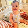 Victoire a rejoint le concours — aidez-le/la à gagner de superbes lots ! baby, child, smiling, crib, cushion, blanket, indoors, sunlight, window, clothing, happy, person, infant, cute, soft, home, interior, sitting, playful, lemon_pattern