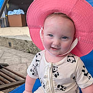 Lucy joined the competition — help win amazing prizes! baby, child, pink_hat, panda_print, romper, smile, blue_eyes, outdoor, lounge_chair, blue_chair, sunhat, cute, happy, infant, summer, vacation, pavement, playful, portrait, person