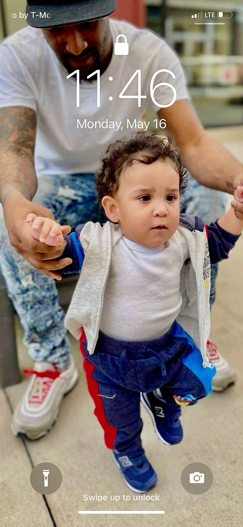 Terrell is registered to the contest to win money with this photo: baby_toddler_clothing, facial_expression, footwear, gesture, hairstyle, hand, happy, head, human_body, interaction, joint, leg, leisure, mammal, person, shoe, skin, sleeve, standing, toddler