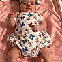 baby, infant, onesie, headband, blanket, unicorn_pattern, pink, white_clothing, red_bows, blue_bows, lying_down, hand_raised, indoor, cute, child, face, person, soft_toys, sleeping_area, baby_accessories