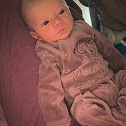 Arthur participe au concours pour gagner de l'argent avec cette photo : baby, infant, onesie, purple_blanket, lion_print, indoor, home, furniture, face, person, sleepwear, cozy, resting, newborn, child, blanket, seated, calm, young, cute