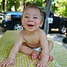 Anthony is registered to the contest to win money with this photo: baby, blurred_background, child, cute, diaper, face, feet, greenery, hands, happy, nature, outdoor, portrait, skin, smiling, sunlight, table, vehicle, water_droplets, yellow_checkered