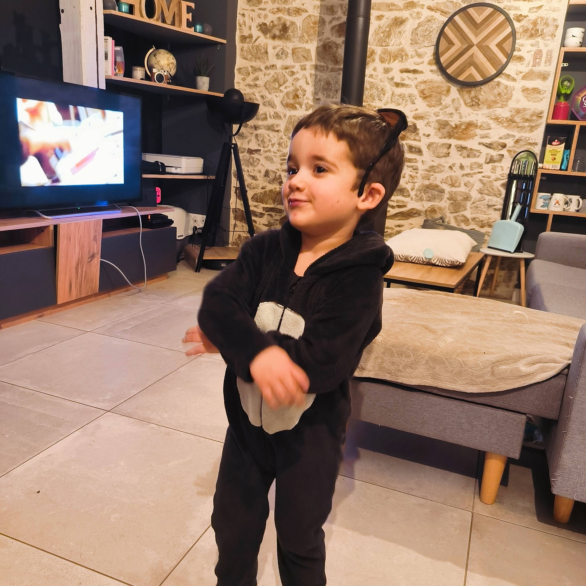 Kaïs participe au concours pour gagner de l'argent avec cette photo : audio_equipment, dartboard, darts, display_device, entertainment_center, event, flat_panel_display, flooring, fun, happy, hardwood, home_appliance, person, shelf, sleeve, standing, t_shirt, television, television_set, toddler