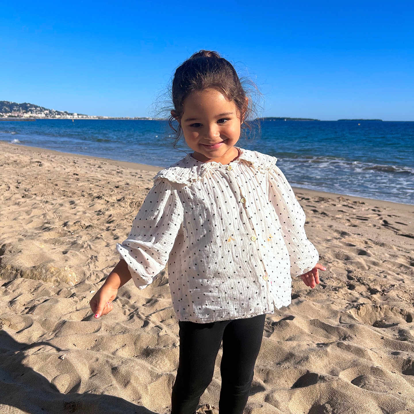 Lilah a rejoint le concours — aidez-le/la à gagner de superbes lots ! barefoot, beach, black_leggings, casual_clothing, child, girl, happy, ocean, outdoor, playful, portrait, sand, shore, sky, smile, summer, sunny, water, waves, white_blouse