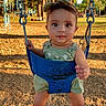 baby, barefoot, bow, child, cute, daytime, fun, green_outfit, infant, outdoor, park, person, play, playground, smiling, summer, sunlight, swing, trees, woodchips