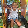 toddler, child, smiling, slide, playground, outdoor, white_shirt, denim_shorts, sneakers, nike, pigtails, happy, grip, metal_slide, sunlight, trees, greenery, summer, fun, play