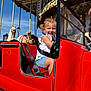 Juliette a rejoint le concours — aidez-le/la à gagner de superbes lots ! child, girl, smiling, carousel, amusement_ride, red_car, seatbelt, pigtails, outdoor, sunny, blue_sky, horse_statue, amusement_park, ride, joyful, fun, summer_clothing, white_top, denim_shorts, playful