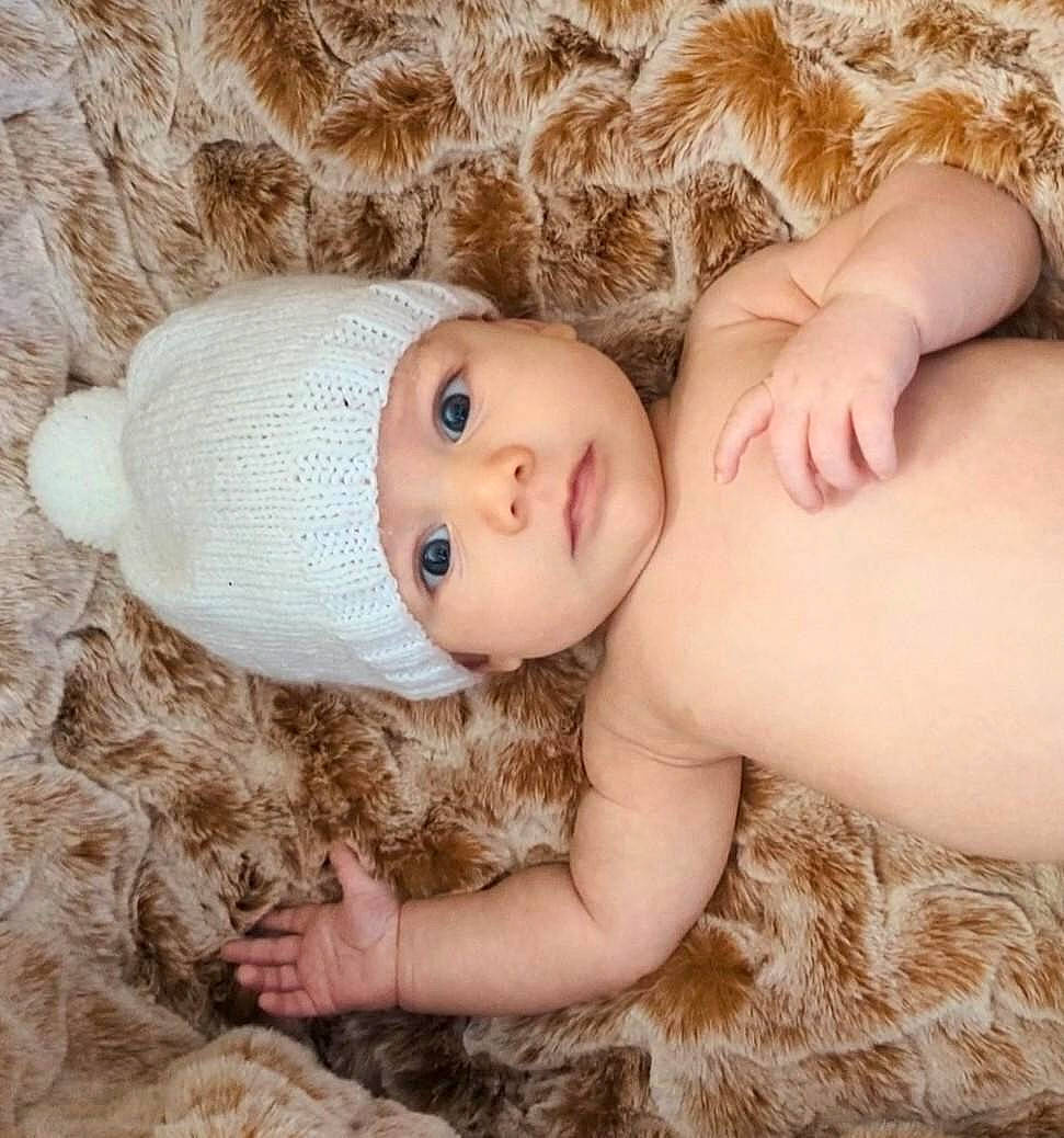 Mac is registered to the contest to win money with this photo: baby, baby_toddler_clothing, cap, child, doll, eye, eyelash, fawn, finger, hand, head, headgear, headwear, human_body, lip, nose, person, plant, skin, toy