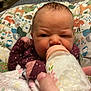 Renee is registered to the contest to win money with this photo: baby, bottle, feeding, blanket, infant, hand, person, face, expression, clothing, bedroom, pillow, animal_print, milk, newborn, cute, indoors, young_child, sleepwear, cozy