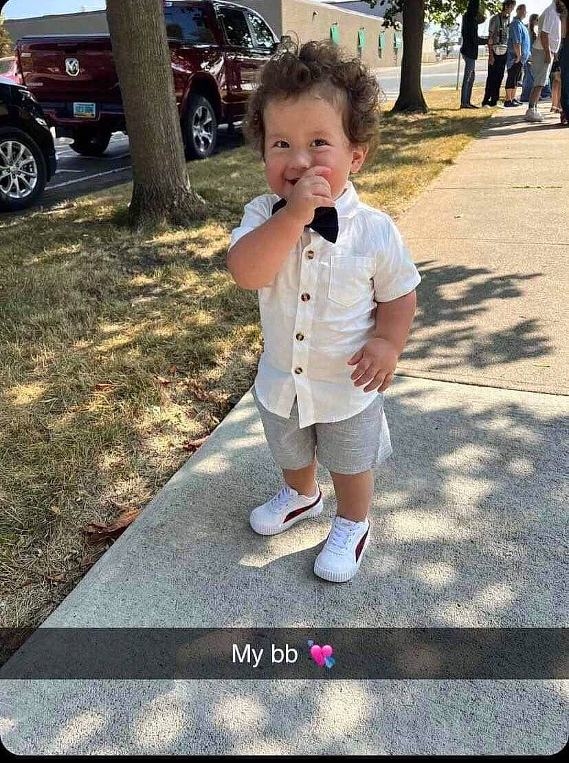 Rylen is registered to the contest to win money with this photo: asphalt, car, child, cool, eyewear, fun, gesture, grass, human_leg, joy, leisure, person, recreation, road, shorts, sidewalk, snapshot, tire, toddler, tree