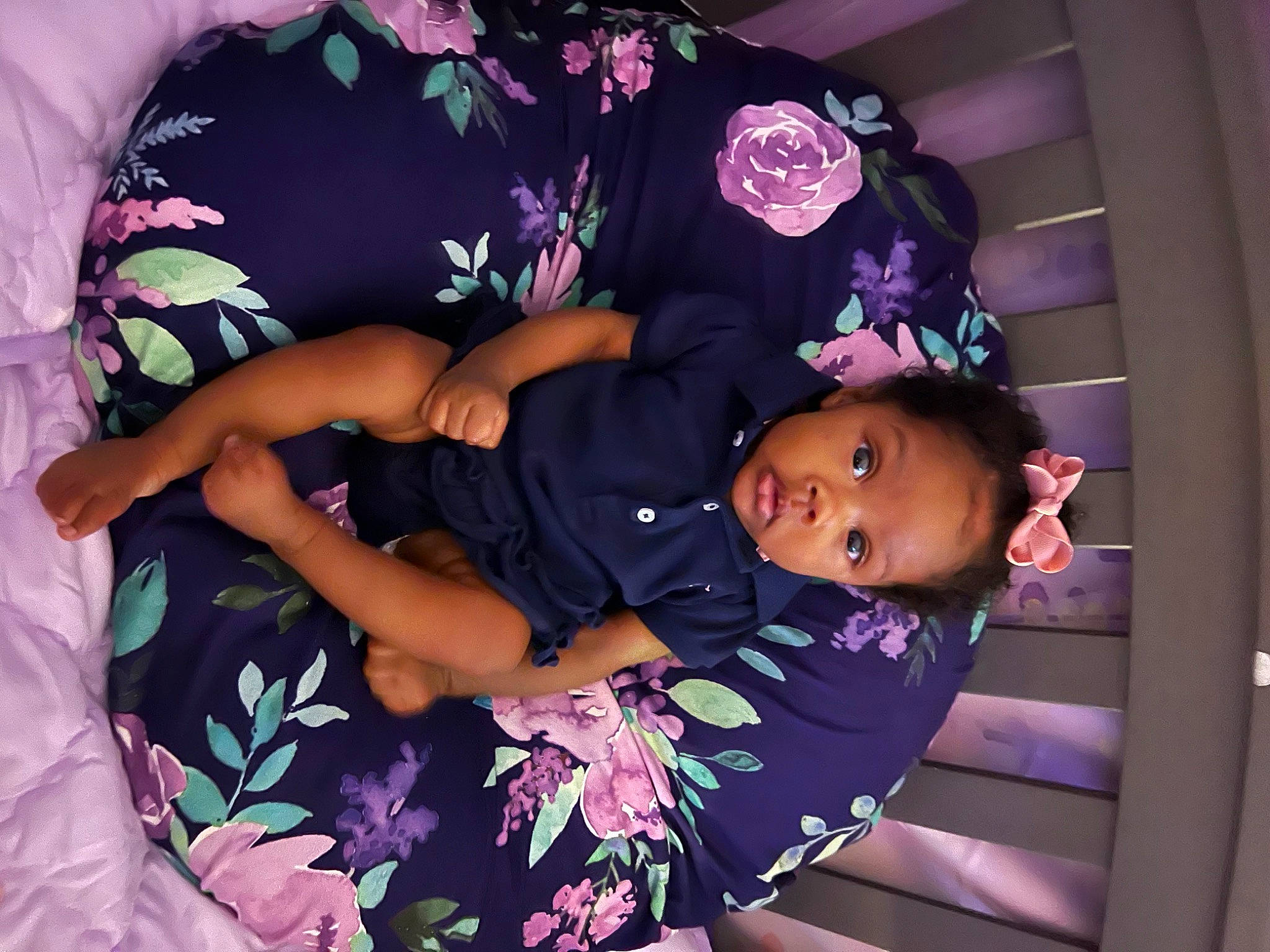 Phallon is registered to the contest to win money with this photo: baby_products, baby_toddler_clothing, child, comfort, happy, hat, magenta, pattern, person, pink, plant, purple, room, skin, sleeve, smile, textile, thigh, toddler, violet