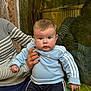 Yanis participe au concours pour gagner de l'argent avec cette photo : baby, infant, child, blue_eyes, blue_sweatshirt, tracksuit, striped_sleeve, painted_nails, holding_hand, portrait, closeup, seated, cheeks, curious_expression, glass_reflection, indoor, wooden_background, casual_clothing, person, portrait_photography