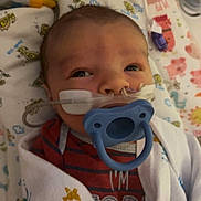 Grayson is registered to the contest to win money with this photo: baby, pacifier, blanket, nasal_cannula, hospital, oxygen_tube, infant, bed, bedding, animal_prints, swaddled, closeup, person, cute, healthcare, newborn, resting, child, indoor, medical