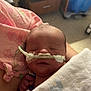 Grayson is registered to the contest to win money with this photo: newborn, baby, infant, blanket, nasal_cannula, hospital, medical, sleeping, swaddled, person, pink_cloth, hand, face, healthcare, caregiver, bedroom, drawer, soft_light, indoor, medical_device