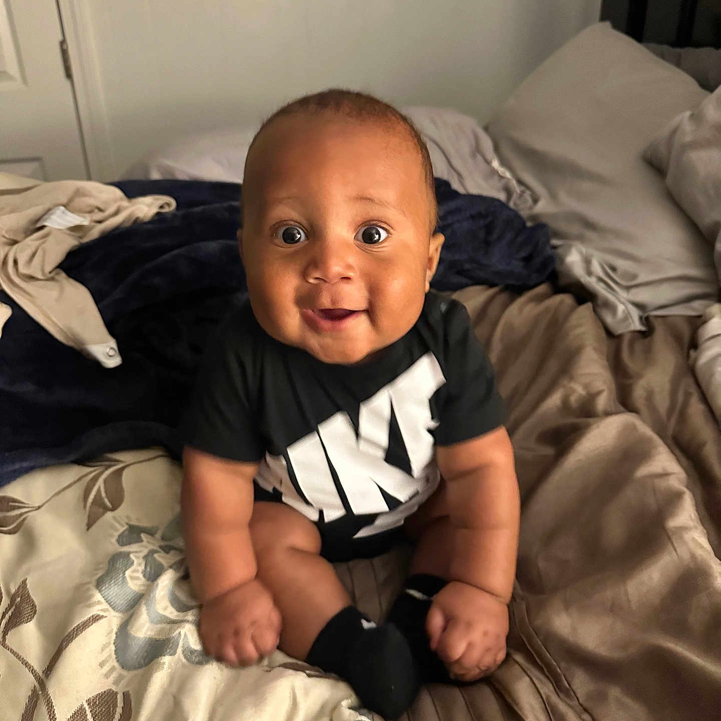 Maddox joined the competition — help win amazing prizes! baby, bed, bedroom, clothing, couch, cushion, face, furniture, glove, happy, head, homedecor, indoors, person, photography, portrait, room, sitting, smile, t_shirt
