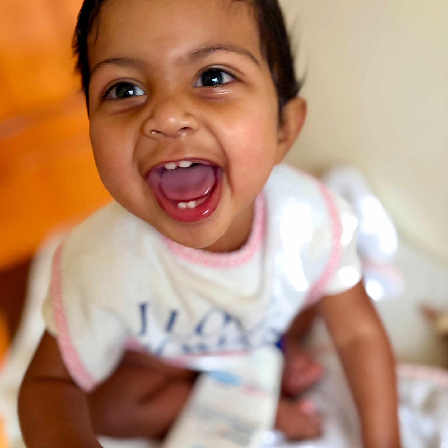 Tevy is registered to the contest to win money with this photo: baby, child, smiling, happy, face, eyes, mouth, hands, cute, indoors, infant, person, skin, clothing, white, pink, blurred_background, joy, expression, portrait