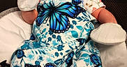 Harlie is registered to the contest to win money with this photo: baby, infant, newborn, blue_butterfly, hat, mittens, blanket, cushion, plush_star, clothing, pattern, cute, face, person, indoors, portrait, seated, baby_seat, soft_toys, child