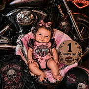Harlie joined the competition — help win amazing prizes! baby, basket, blanket, clothing, cute, decor, floor, harley_davidson, headband, helmet, indoor, infant, leather_jacket, motorbike, motorcycle, one_month_old, pink, portrait, sign, smile