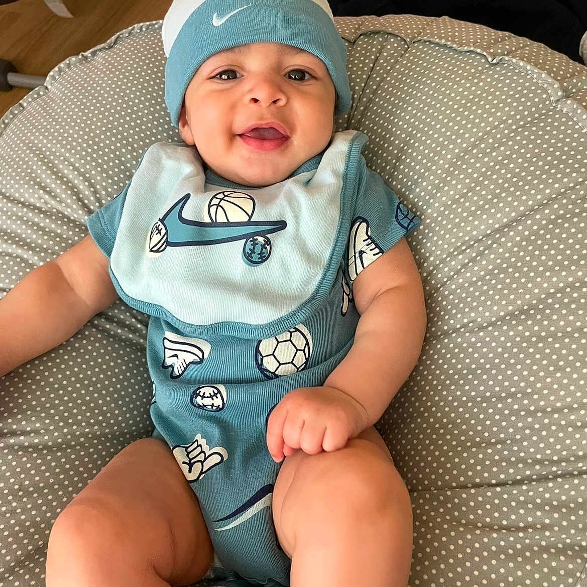Luka joined the competition — help win amazing prizes! baby, bib, blue_clothing, child, closeup, cushion, cute, face, foot, hand, happy, hat, indoor, infant, onesie, person, polka_dot, sitting, skin, smile