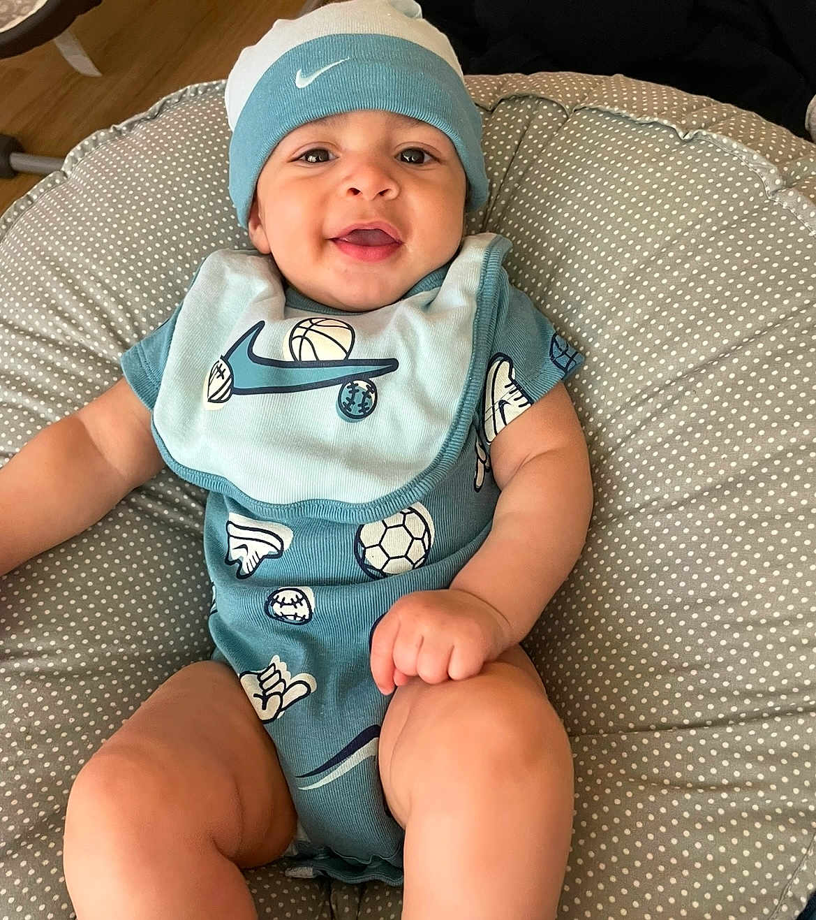 Luka joined the competition — help win amazing prizes! baby, bib, blue_clothing, child, closeup, cushion, cute, face, foot, hand, happy, hat, indoor, infant, onesie, person, polka_dot, sitting, skin, smile