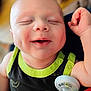 Cyrus is registered to the contest to win money with this photo: baby, infant, smiling, dimple, pacifier, clothing, black_shirt, green_trim, happy, cute, portrait, child, face, skin, arm, hand, indoors, closeup, soft_light, blurred_background