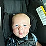 baby, blue_eyes, car_seat, child, cute, face, infant, playful, seatbelt, straps, safety, blanket, clothing, portrait, closeup, expression, human, indoors, young_child, smiling