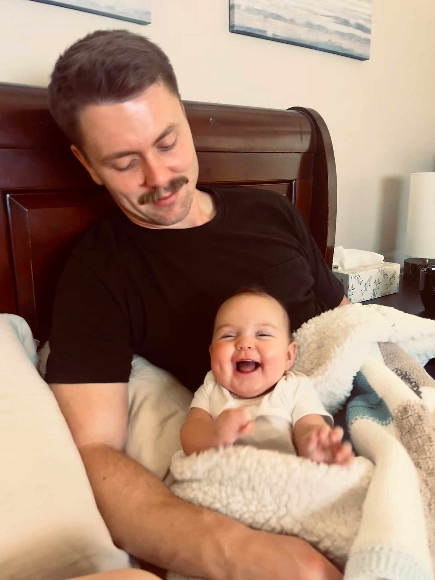 Vivian is registered to the contest to win money with this photo: baby, man, smiling, laughing, blanket, bed, pillow, mustache, indoor, person, head, happy, clothing, furniture, home, portrait, parent, child, cozy, family
