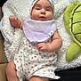 baby, infant, headband, floral, romper, blanket, plush_toy, turtle, cute, chubby_cheeks, indoors, soft_texture, clothing, sitting, child, face, expression, comfort, young, adorable