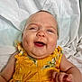 Vivian is registered to the contest to win money with this photo: baby, child, smiling, yellow_dress, floral_pattern, cute, portrait, happy, infant, skin, face, hand, lying_down, white_background, clothing, person, cheeks, expression, indoors, young