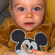 Eden participe au concours pour gagner de l'argent avec cette photo : baby, child, blue_eyes, mickey_mouse, sweater, blanket, couch, indoor, closeup, face, hands, cute, soft_texture, cozy, infant, portrait, young_child, expression, holding, furniture