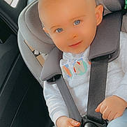 Eden a rejoint le concours — aidez-le/la à gagner de superbes lots ! baby, blue_eyes, car_interior, car_seat, child, cute, hands, happy, indoors, infant, light_blue_pants, person, portrait, safety, seat_belt, seat_headrest, secured, smiling, white_sweater, young_child