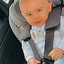baby, blue_eyes, car_interior, car_seat, child, cute, hands, happy, indoors, infant, light_blue_pants, person, portrait, safety, seat_belt, seat_headrest, secured, smiling, white_sweater, young_child