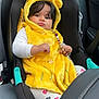 baby, child, car_seat, yellow_hood, hooded_vest, beads, toy, infant, clothing, heart_pattern, leggings, car_interior, seatbelt, cute, portrait, indoor, sitting, expression, young_child, warm_clothing