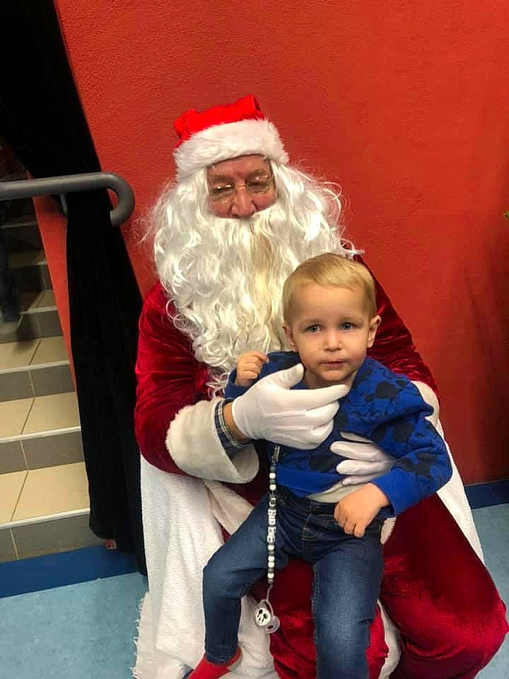 Liam participe au concours pour gagner de l'argent avec cette photo : christmas, christmas_eve, fictional_character, headwear, holiday, human_body, lap, person, santa_claus, toddler