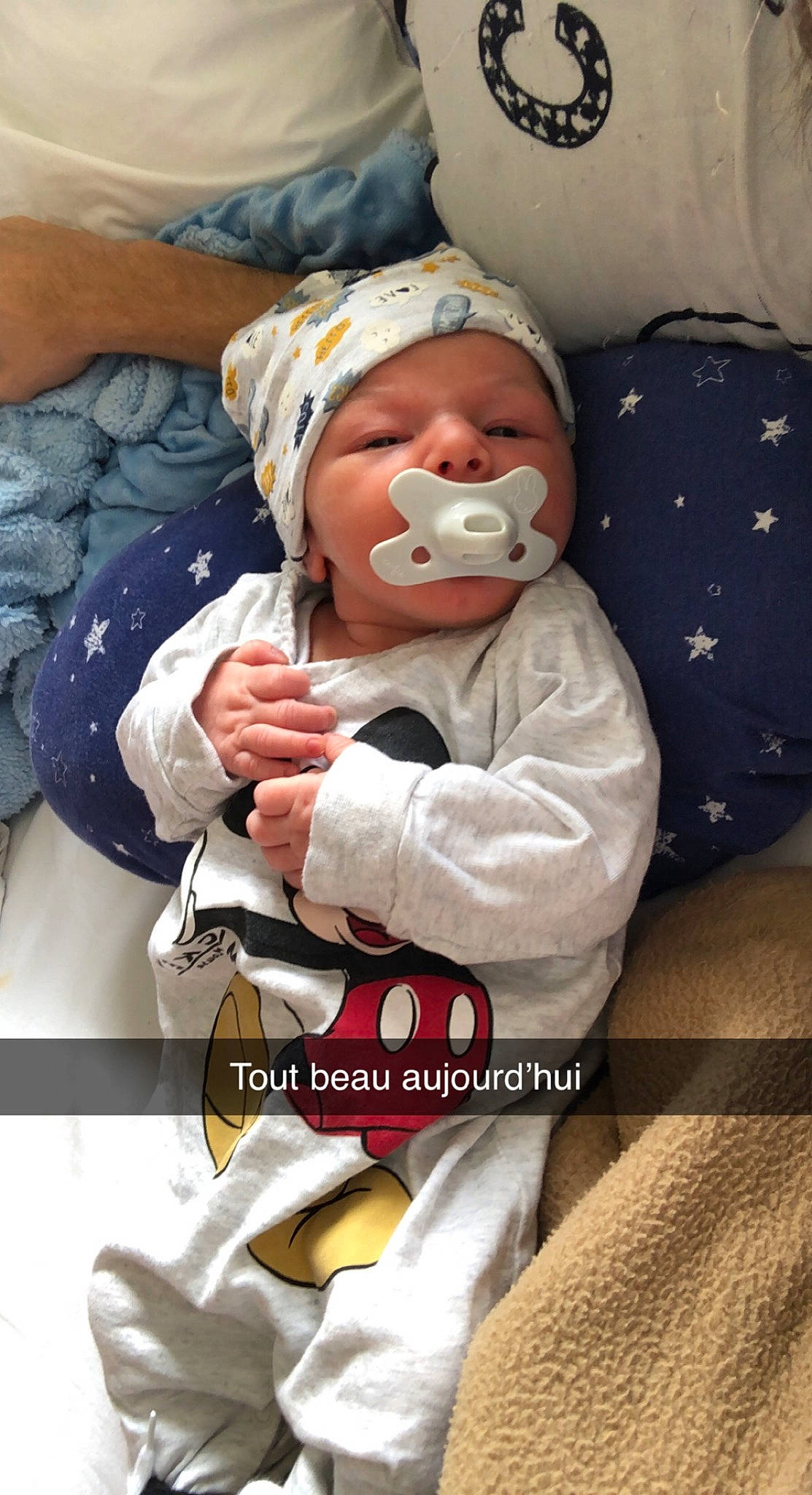 Lyam a rejoint le concours — aidez-le/la à gagner de superbes lots ! baby, baby_products, baby_safety, baby_sleeping, baby_toddler_clothing, cap, cheek, child, comfort, gesture, glove, happy, hat, headwear, person, photo_caption, service, sitting, sleeve, thumb