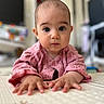 baby, infant, child, pink_clothing, floor, hands, face, eyes, indoor, toy, blurred_background, home, crawling, person, young_child, curious, portrait, cute, earrings, soft_light
