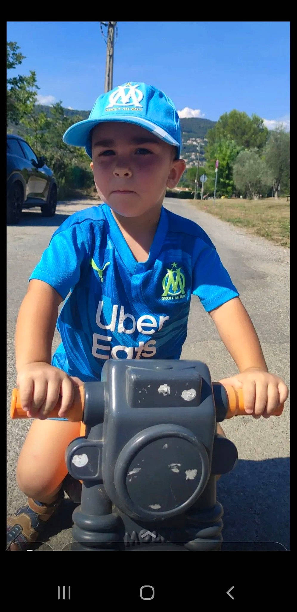Mattéo participe au concours pour gagner de l'argent avec cette photo : automotive_tire, baseball_cap, blue, cameras_optics, cap, child, electric_blue, flash_photography, fun, grass, happy, headwear, leisure, person, personal_protective_equipment, plant, recreation, sky, t_shirt, toddler