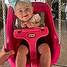 Adalyn is registered to the contest to win money with this photo: baby, child, swing, pink, blue_bow, smiling, drool, concrete_floor, wooden_post, hand, black_shoes, black_shorts, white_shirt, toy, playground, happy, person, ropes, seat, indoor