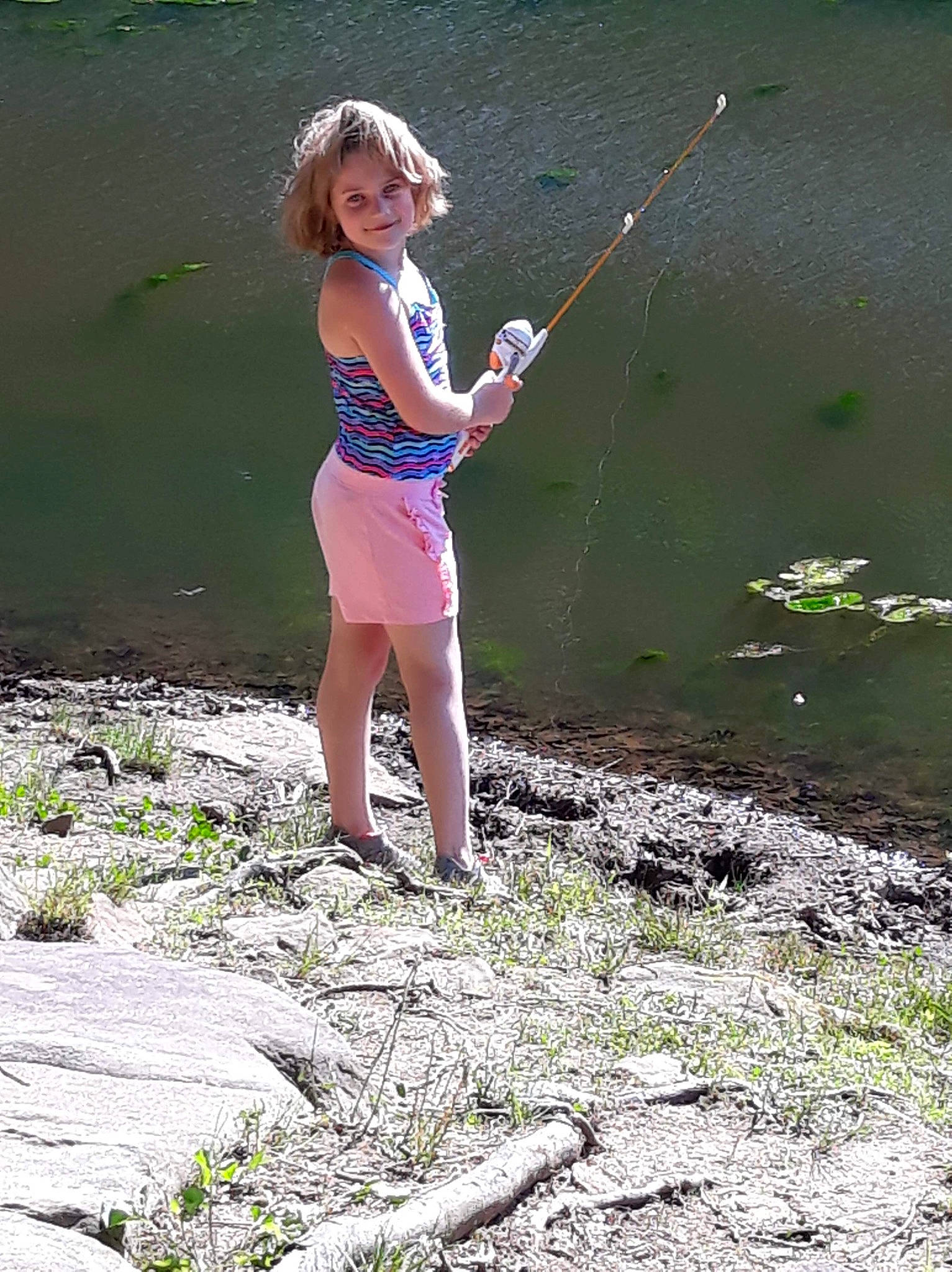 Cassie is registered to the contest to win money with this photo: angling, barefoot, fishing, fishing_rod, fun, grass, joy, person, play, recreation, recreational_fishing, water